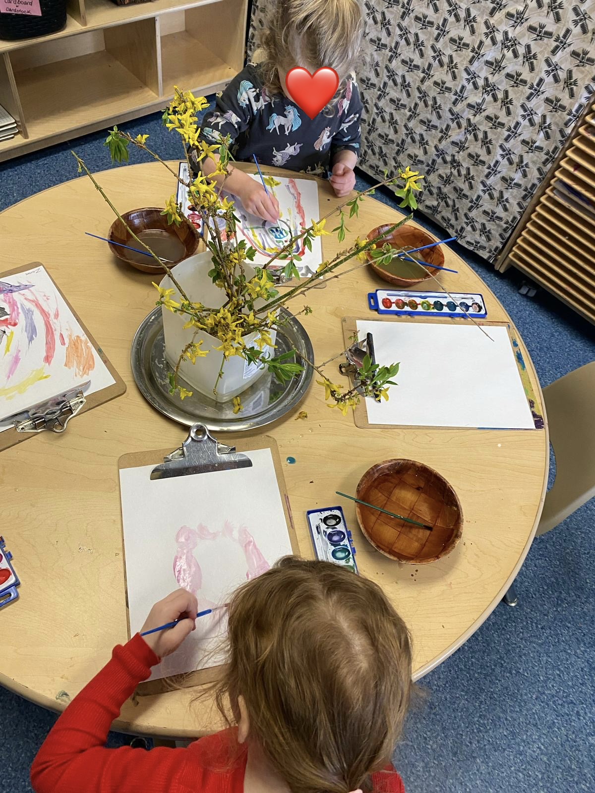 preschool children painting at a table